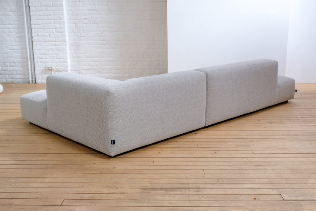 Un canapé blanc posé sur un parquet en bois.