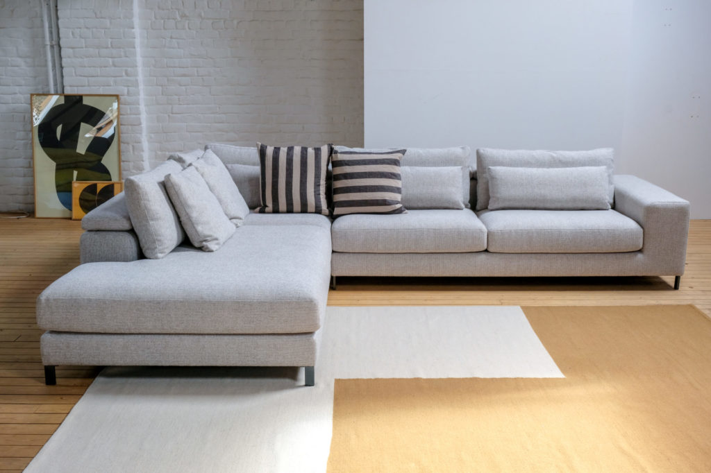 Un canapé sectionnel dans un salon avec un tapis.