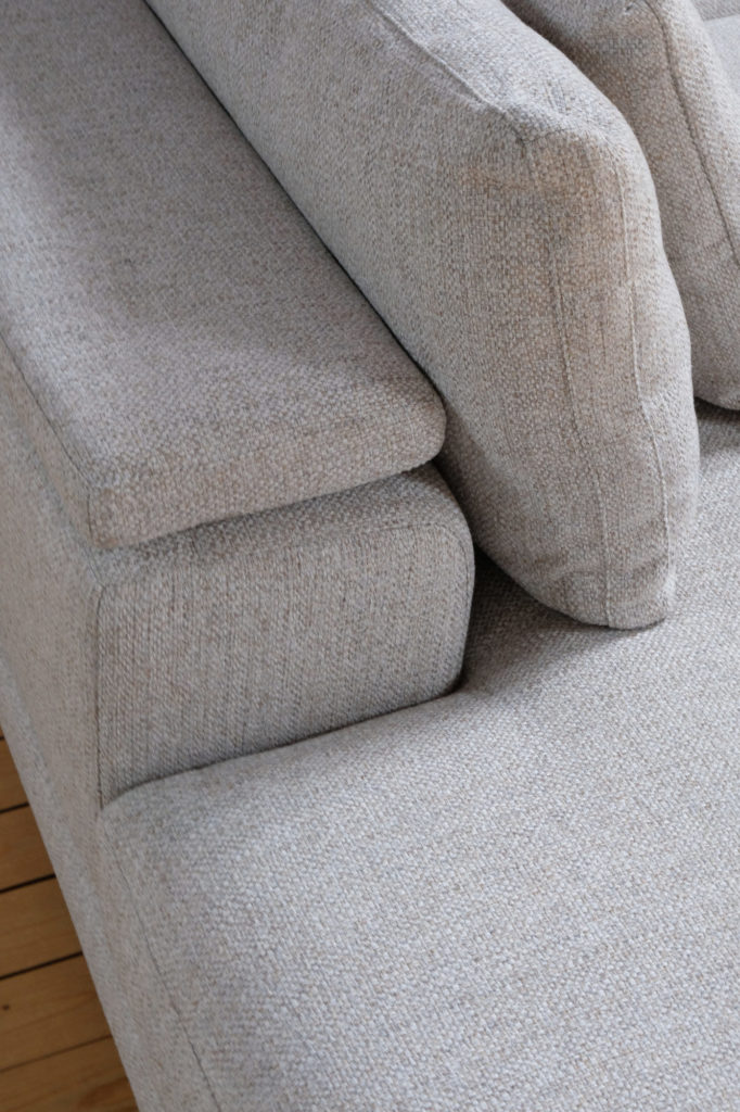 Un canapé sur un parquet.