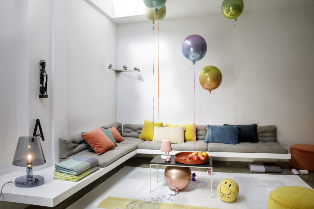 Un salon avec le mélange Tapis Color suspendu au plafond.