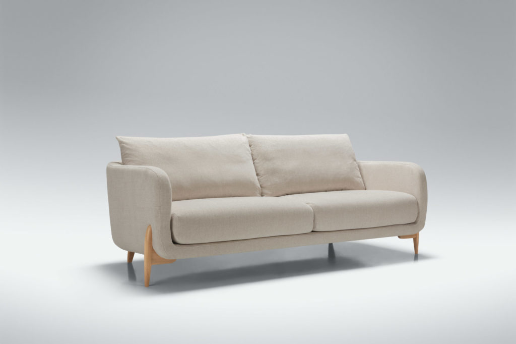 Un Canapé Jenny, 3 places avec pieds en bois sur fond gris à 3 places.