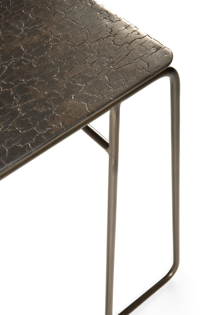 Une Table d'appoint Ellipse avec un cadre en métal noir.