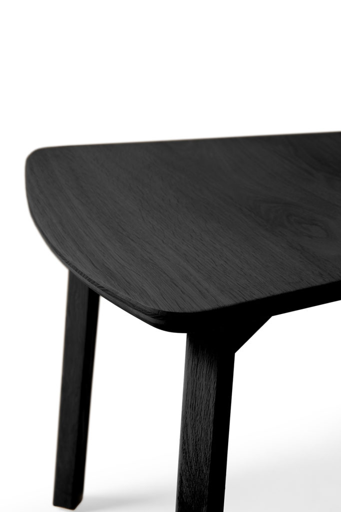 Une table Chaise Casale en chêne noir en bois noir avec un pied courbé.