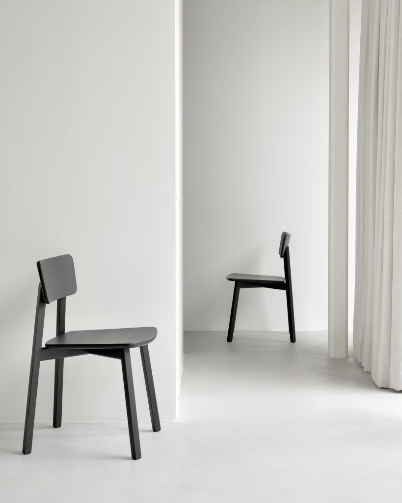 Une paire de chaises Chaise Casale en chêne noir dans une pièce avec un rideau blanc.