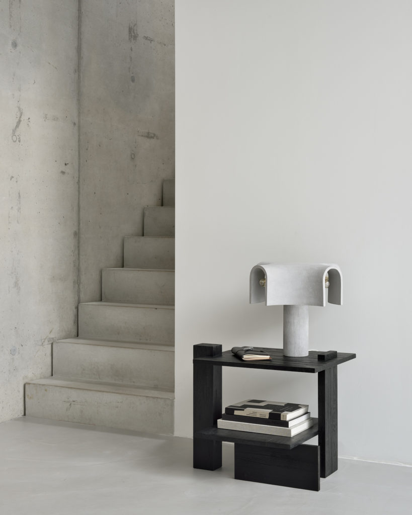 Une table d'appoint Table d'appoint Abstract en teck à côté d'un escalier.
