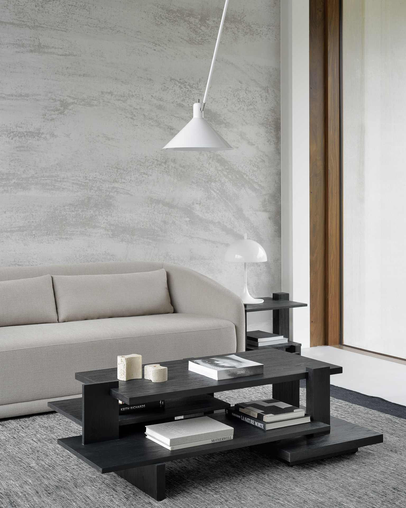 Un salon moderne avec une table basse noire et une Table d'appoint Abstract en teck.