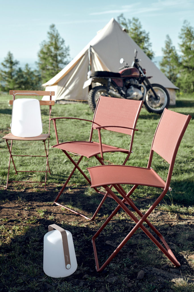 Une chaise pliante rouge et une moto devant une tente, bien en évidence sur la bannière coulissante principale du site Web VP22.