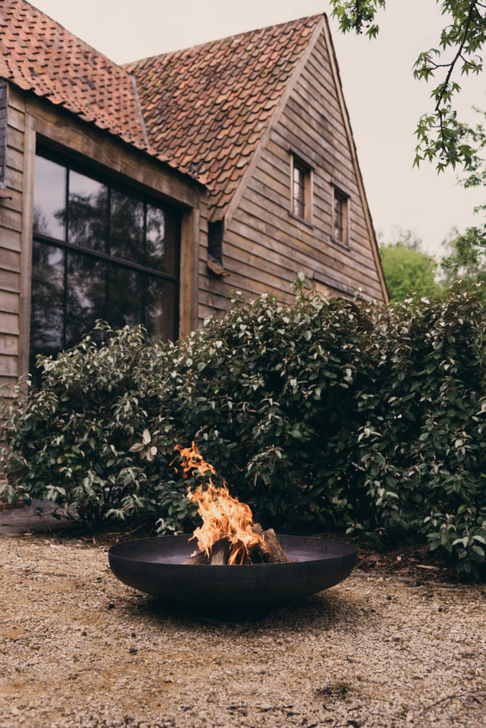 Un Bol à feu Jesco noir devant une maison.