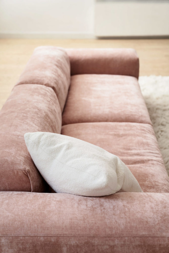 Un modèle de canapé rose qui se trouve dans un salon.