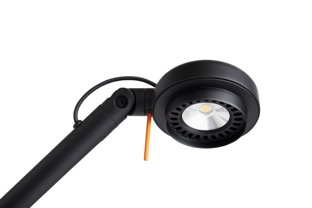 Une lampe de bureau Fifty Fifty noire avec une lumière orange attachée à celle-ci.