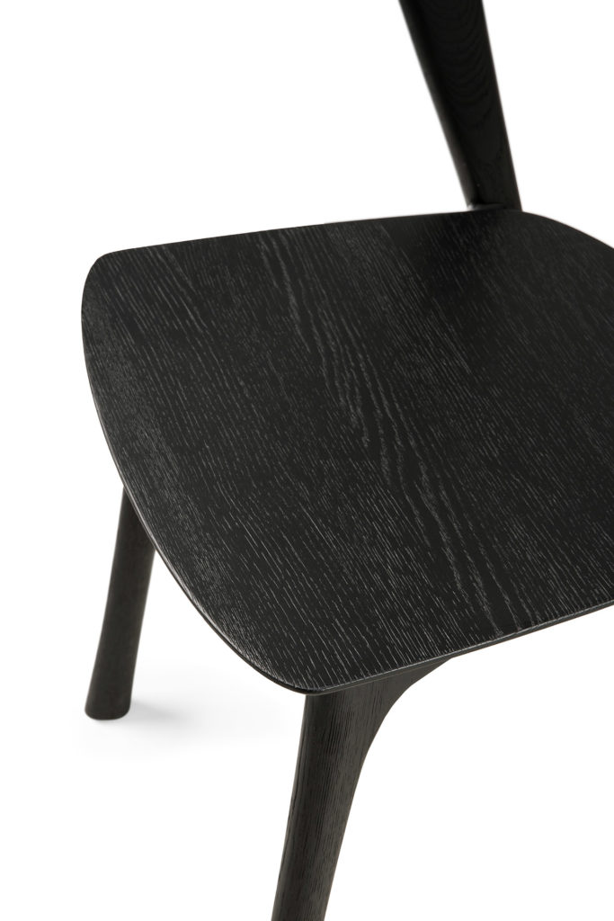 Un gros plan d'une chaise en bois noir, plus précisément la Chaise Bok en chêne noir, chaise noire.