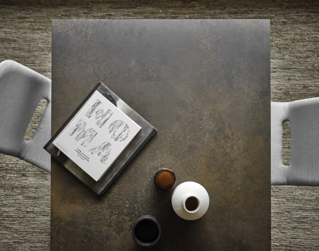 Une table Terra extensible avec un livre et une tasse de café.