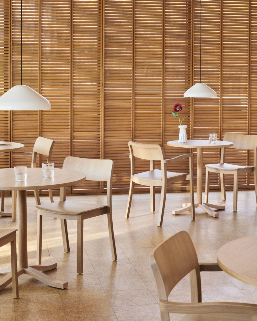 Une salle à manger avec tables et chaises en bois, idéale pour déguster une Chaise Pastis et savourer les saveurs d'une délicieuse Chaise Pastis.