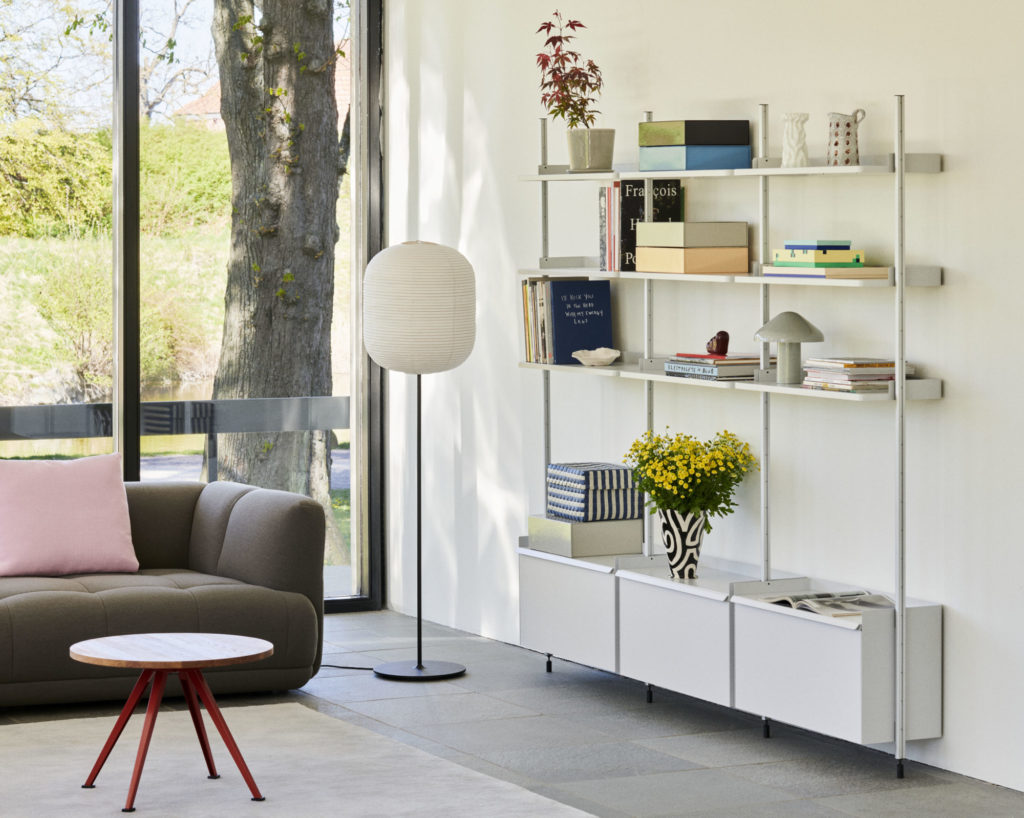 Un salon avec un canapé et des étagères.