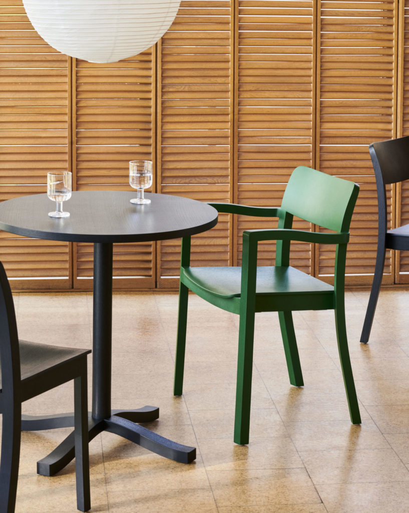 Une Chaise Pastis avec accoudoirs et chaises dans une chambre.