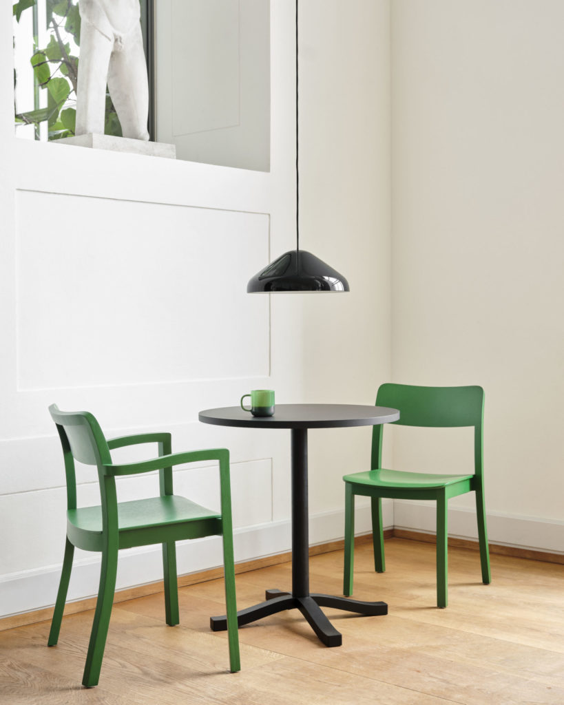 Deux Chaises Pastis avec accoudoirs verts et une table dans une pièce.