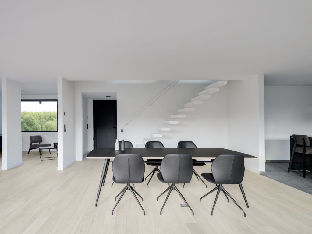 Un salon moderne avec une table noire et des chaises Chaise Mood 91.