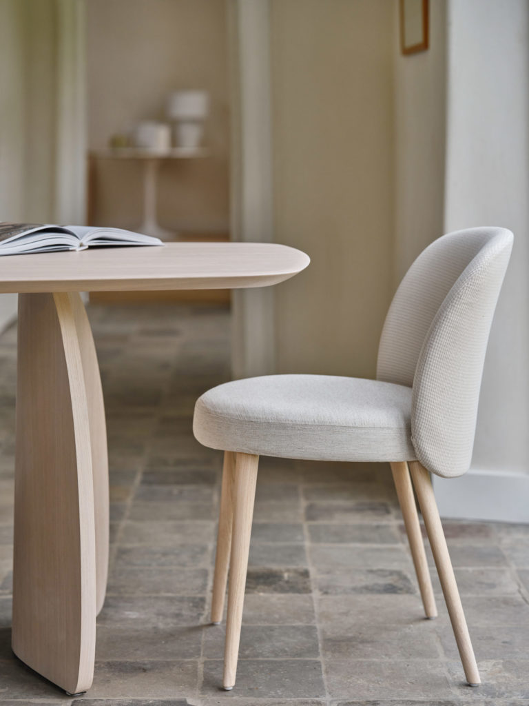 Une chaise Neo et une table avec un livre dessus dans un style néo.