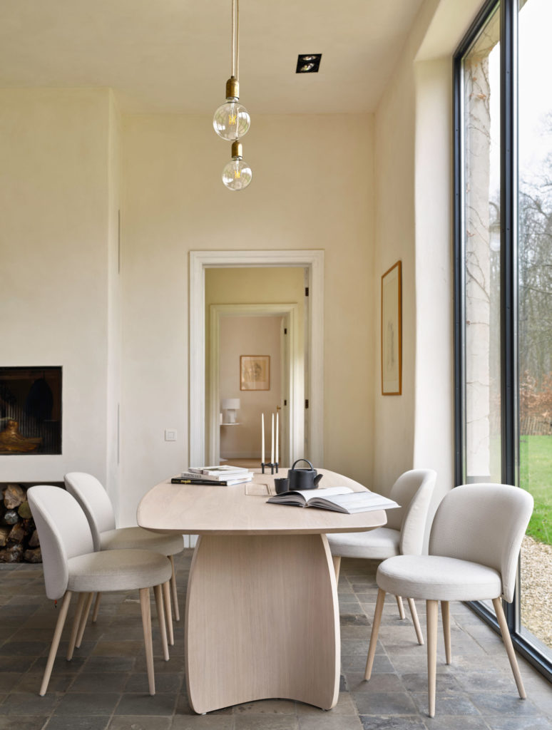 Une salle à manger avec une table et des chaises en bois, au design Chaise Neo.