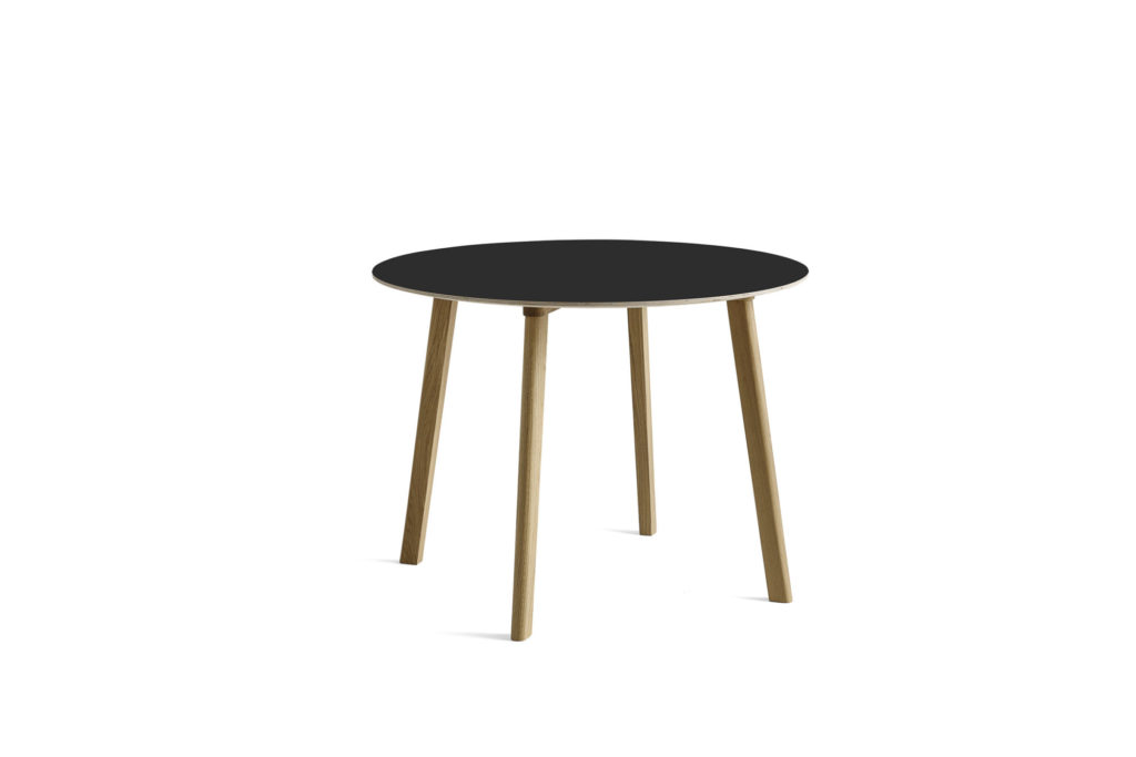 Une table ronde CPH Deux avec un plateau noir et des pieds en bois, mesurant un diamètre de 98 cm.