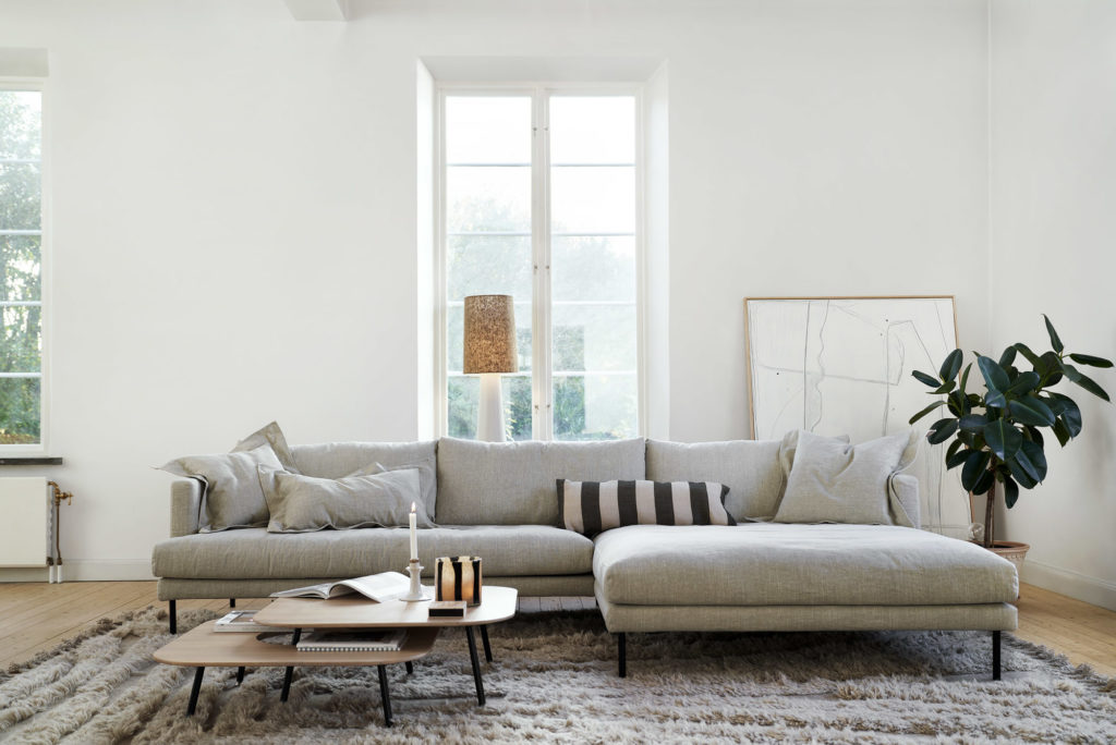 Un salon blanc avec un Canapé Britt conçu par Britt.