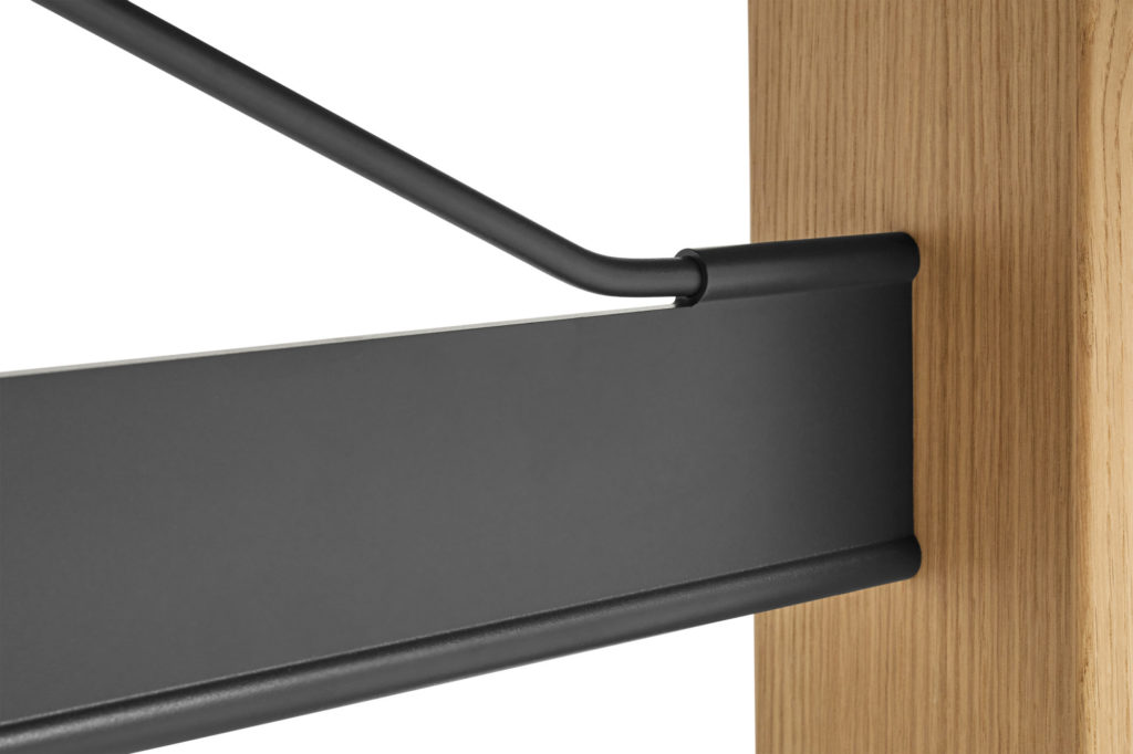 Gros plan d'une étagère en bois avec une barre en métal noir servant de Table Passerelle.