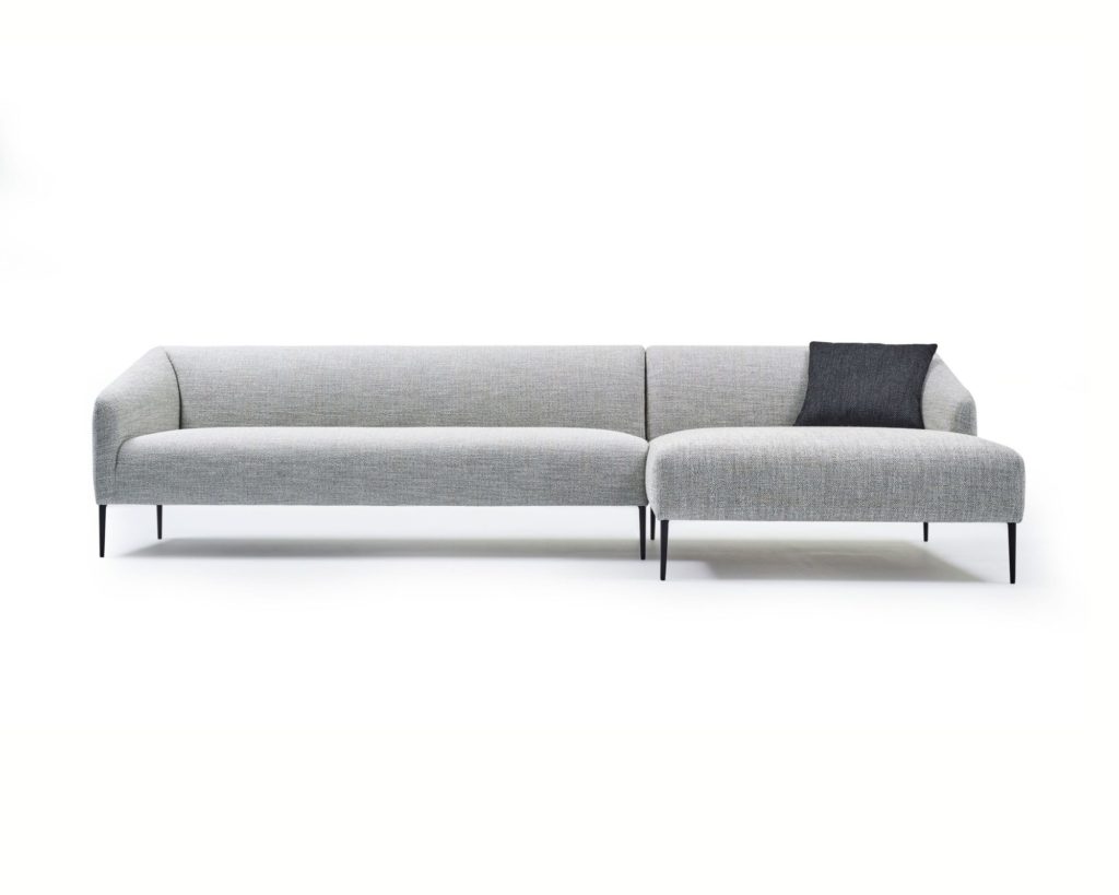 Un canapé sectionnel gris avec un oreiller noir, également connu sous le nom de Canapé Kylie.