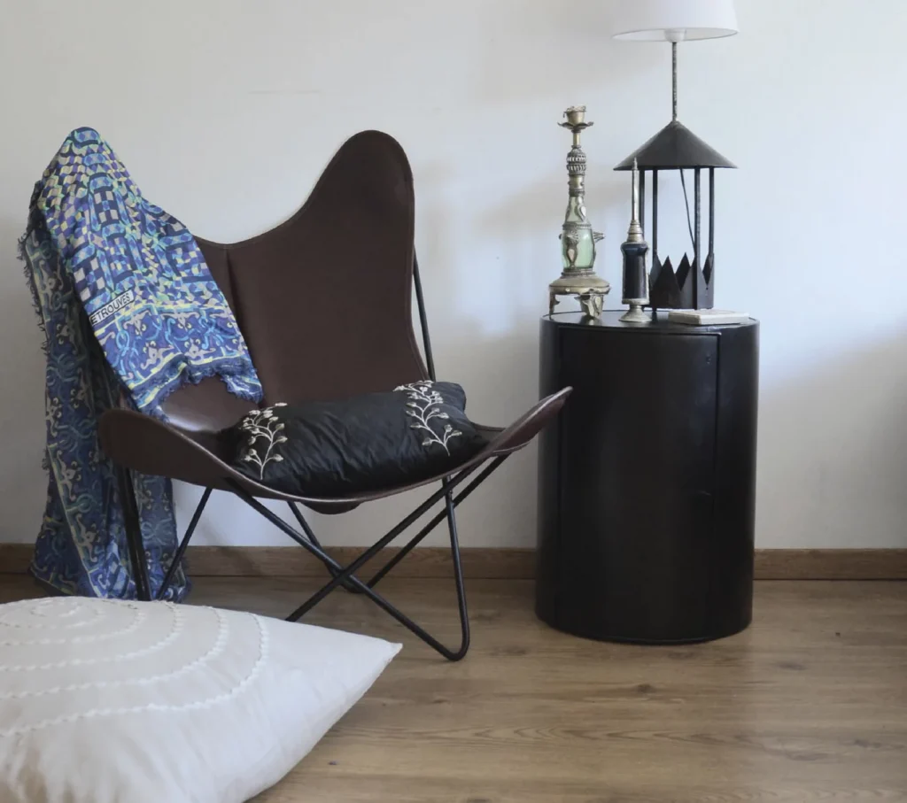 Un fauteuil AA, cuir noir et brun dans une pièce avec une lampe.