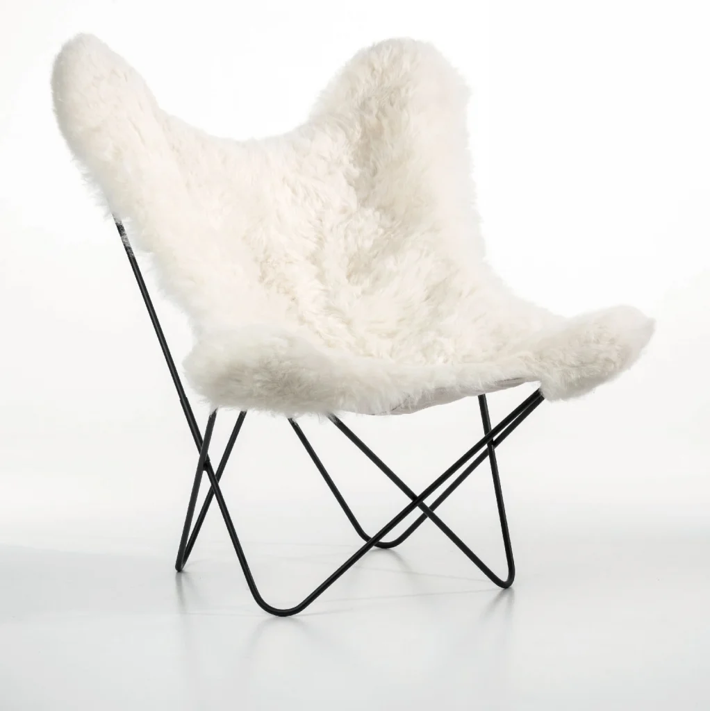 Une chaise Fauteuil AA blanche avec une assise en mouton blanc.