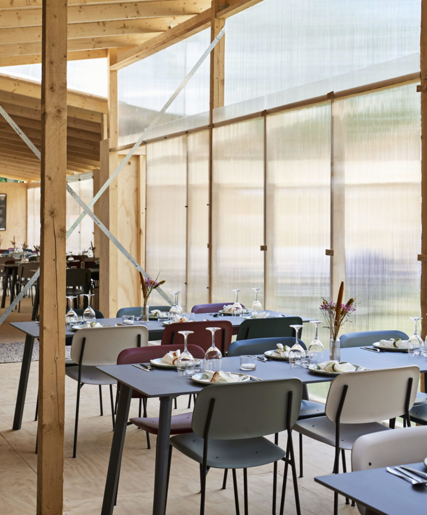 Un restaurant avec Table carrée CPH Deux 210, 75 x 75 cm et chaises dans un bâtiment en bois appelé CPH Deux.