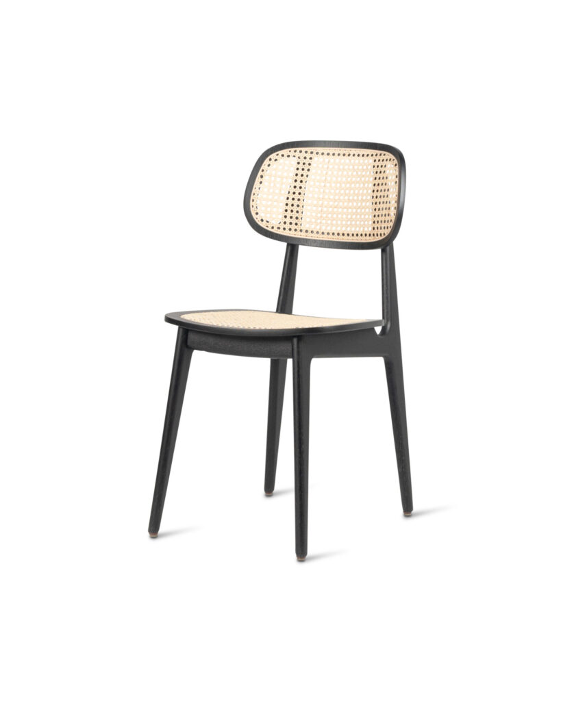 Présentation de la Chaise Titus : une chaise en bois raffinée avec une structure noire et un siège et un dossier en rotin tressé élégant.