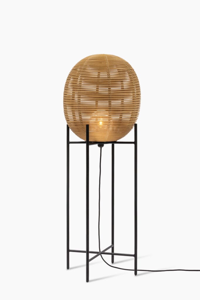 Un lampadaire avec une boule en bois sur un pied noir, appelé Lampe Sari.