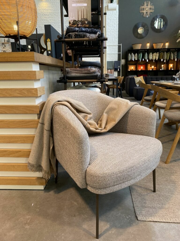 Une chaise Fauteuil Lennox dans un magasin avec une couverture dessus.
