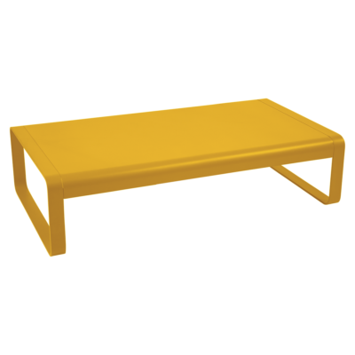 Une table basse Bellevie jaune sur fond noir.