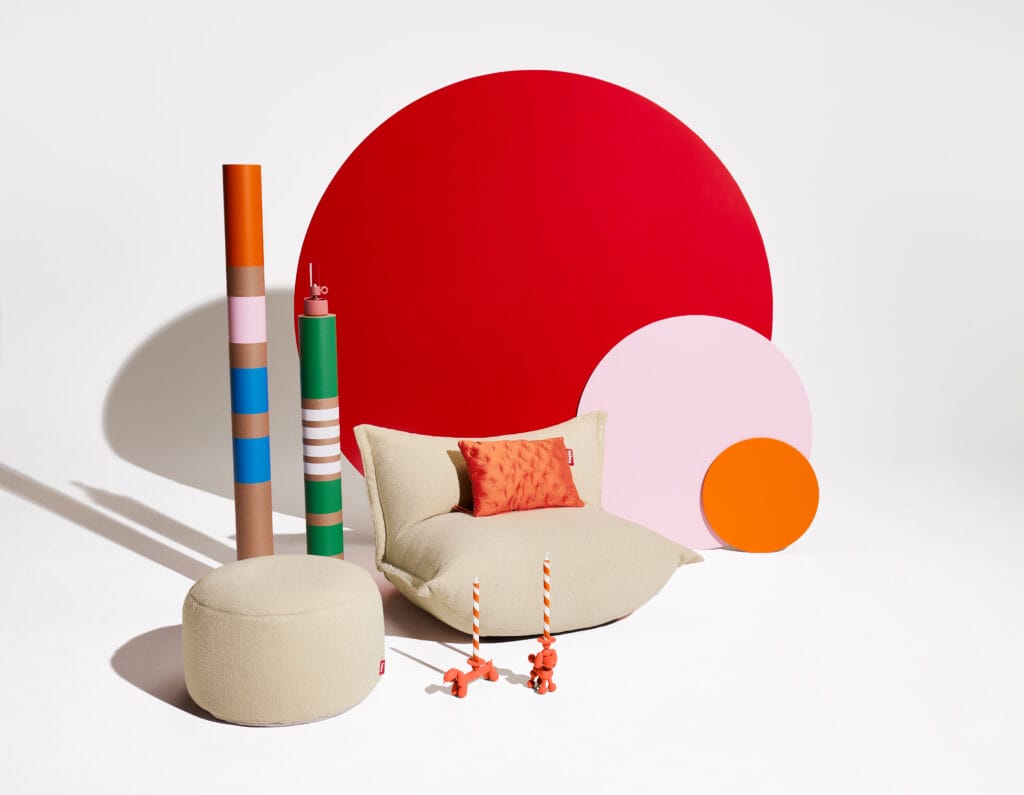 Une chaise Pouf Point Large Sherpa rouge, orange et jaune et une lampe rouge, orange et jaune.