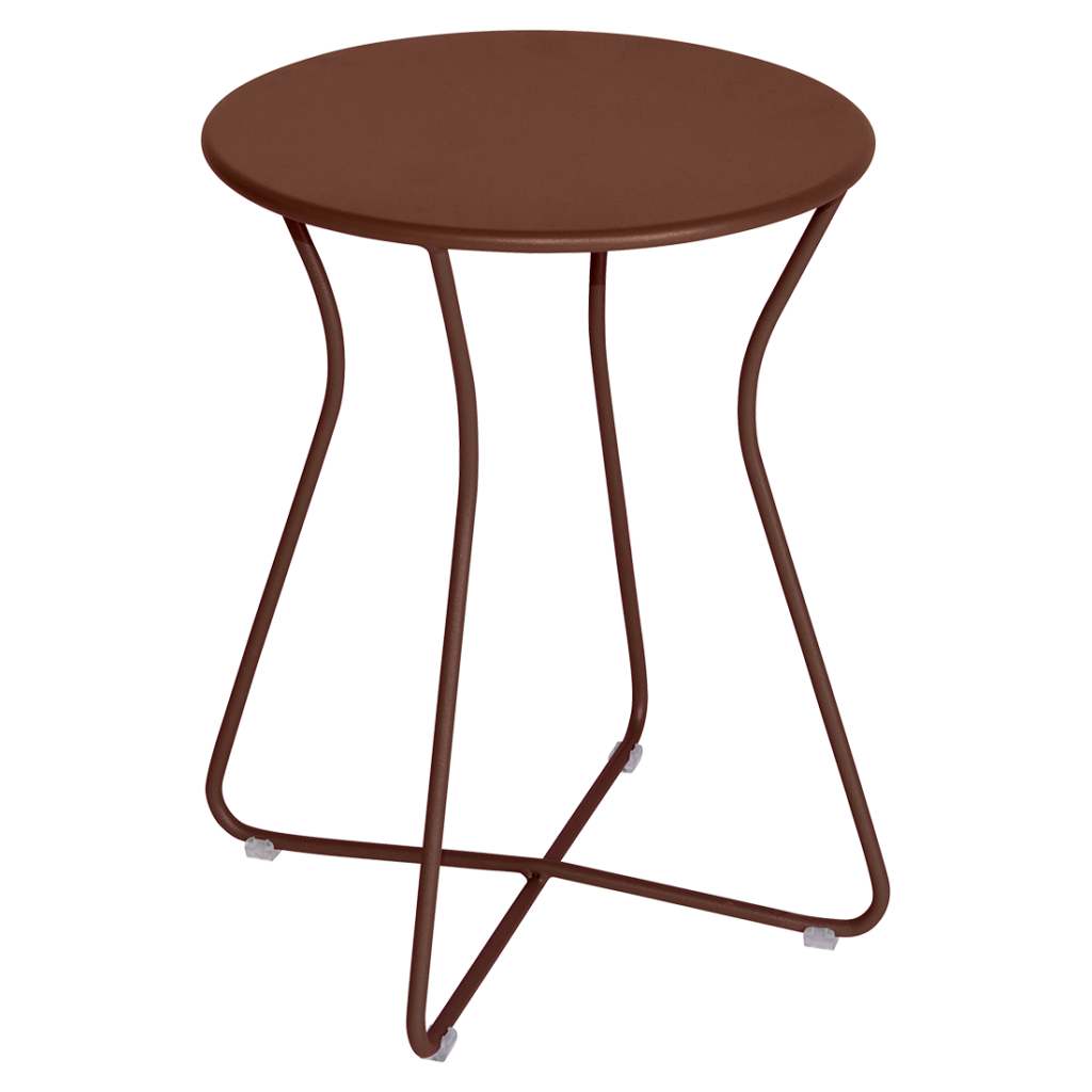 Une table ronde avec un piètement en métal marron et un Tabouret Cocotte.