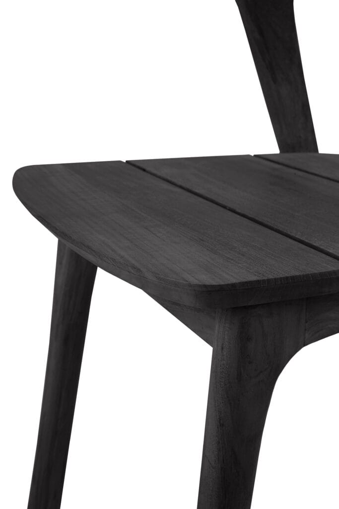 Un gros plan d'une chaise de jardin Bok en teck noir.