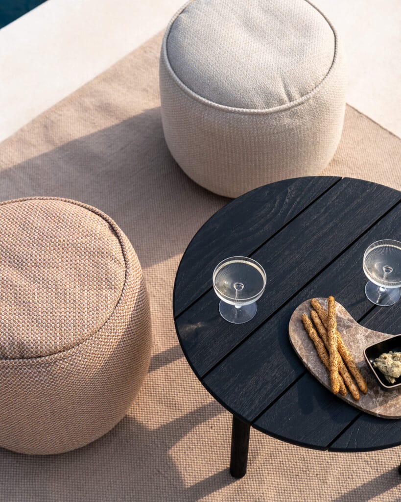 Une table avec deux Pouf de jardin Donut au bord d'une piscine.