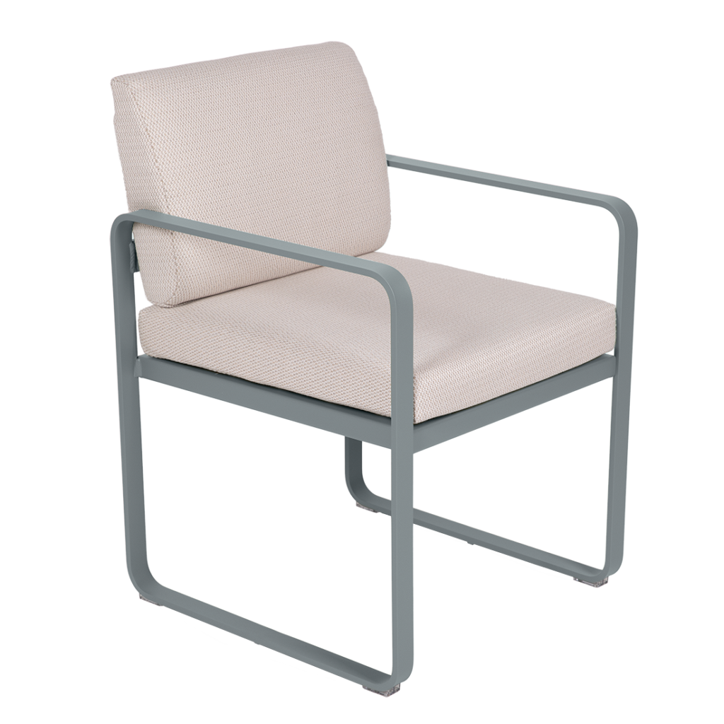 Le Fauteuil de repas Bellevie est doté d'une assise et d'un dossier rembourrés beige clair avec une structure en métal gris minimaliste, comprenant des accoudoirs et des pieds incurvés.