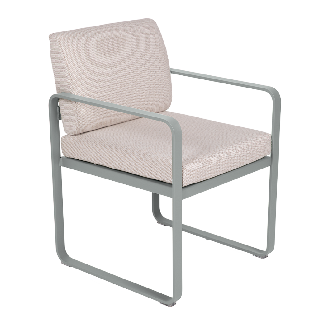 Le Fauteuil de repas Bellevie est doté d'une structure en métal gris clair, d'accoudoirs droits et d'une assise et d'un dossier rembourrés en tissu beige clair, présentés sur un fond blanc.