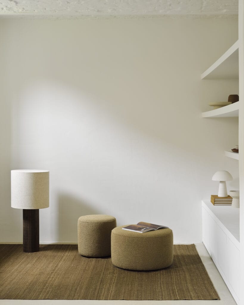 Une chambre blanche avec un tapis Tapis Kilim Nomad et une lampe.