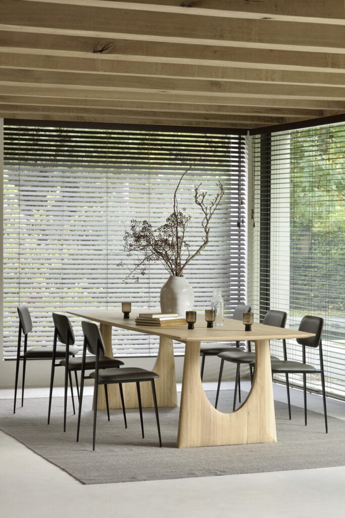 Une salle à manger avec une table et des chaises en bois ornées d'un Tapis Kilim Nomad.