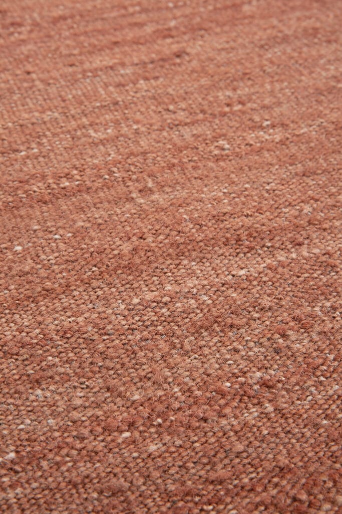 Une image en gros plan d’un tapis tissé rouge.