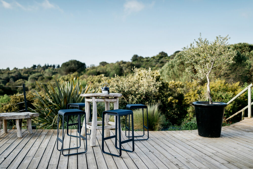 Une terrasse en bois avec une table et des chaises Tabouret de bar Bellevie.
