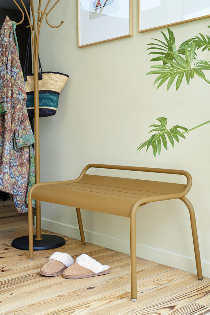 Un Banc compact Luxembourg dans une pièce avec une plante dessus.