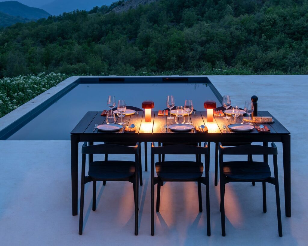 Une Table de jardin Bok en teck noir avec des chaises.
