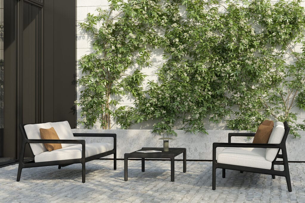 Un ensemble de Canapé de jardin Jack en teck noir - 2 places en noir et blanc avec une plante sur le mur.