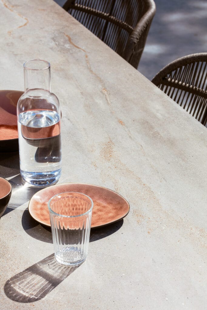 Un ensemble d'assiettes et un verre d'eau sur une table Kodo.