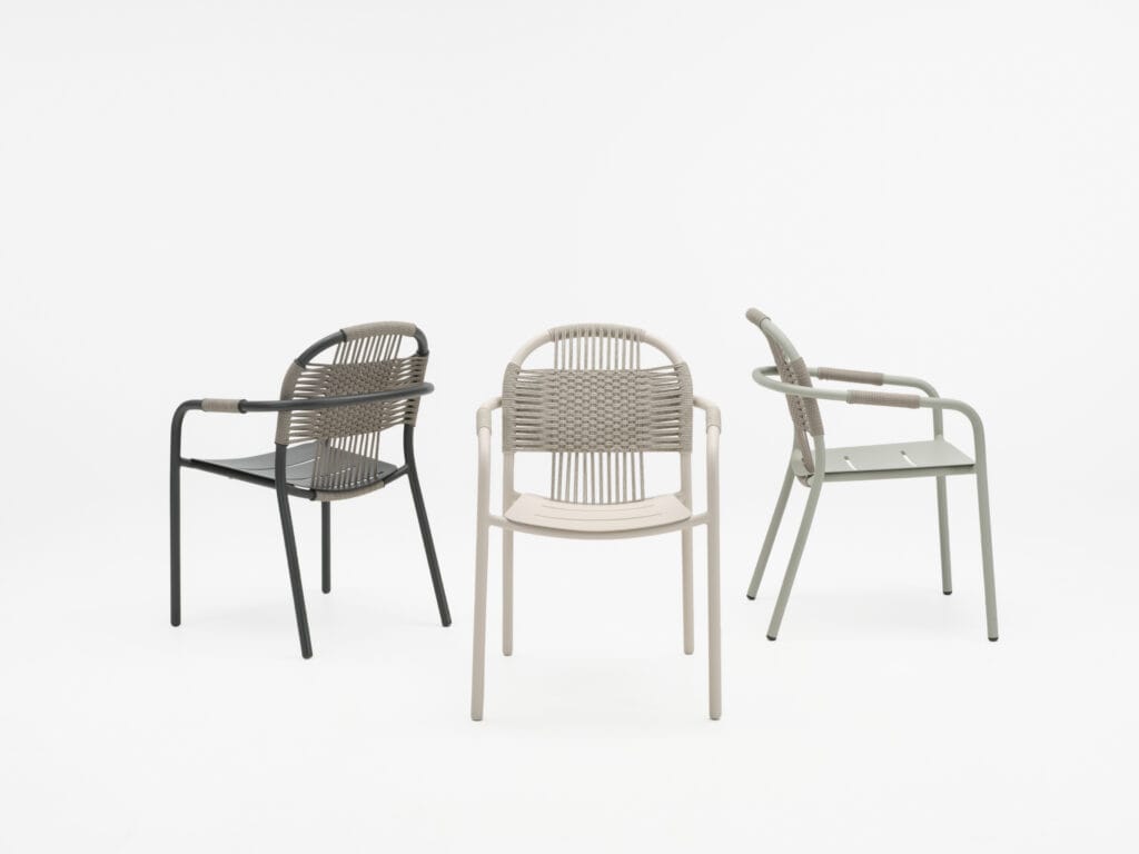 Trois chaises Cléo en osier avec accoudoirs sur fond blanc.