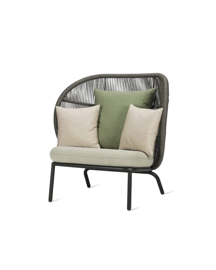 Une chaise en osier Fauteuil Cocoon Kodo avec des oreillers verts et un cadre noir.